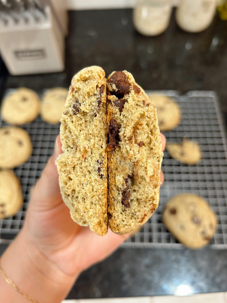 Two cookies broken in half, held side by side to compare the textures and colors