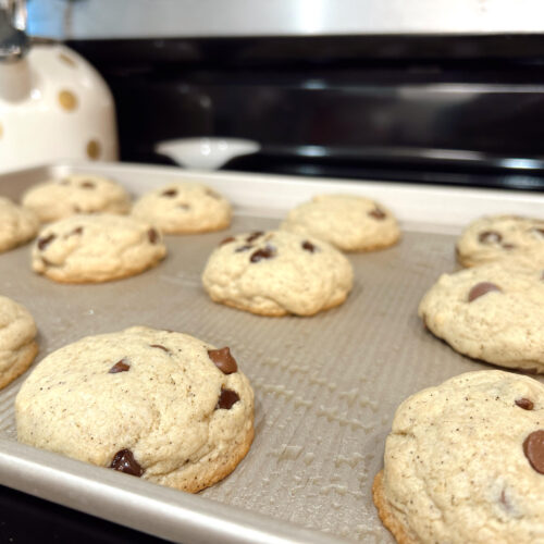 Freshly baked browned butter sourdough chocolate chip cookies on a baking sheet