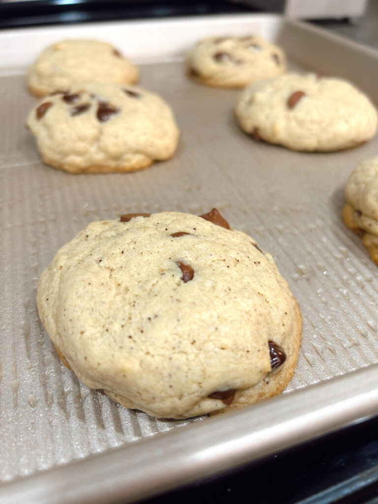 Browned butter sourdough chocolate chip cookies on a baking sheet fresh from the oven.